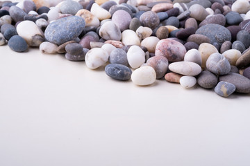 Varied pebbles on white background angle view