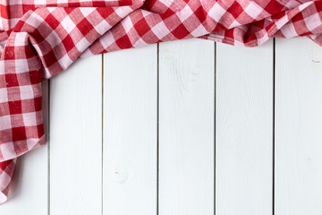 Red-white kitchen tablecloth on a white table. View from the top.