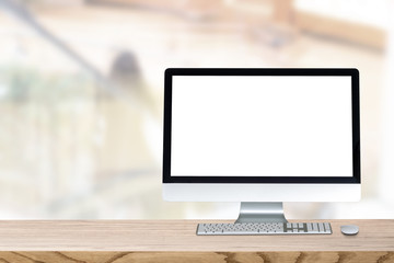 Blank screen desktop computer on plank wooden table top with blur background. Office interior with blurry background.