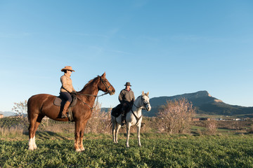 Man and woman riding horses on ranch