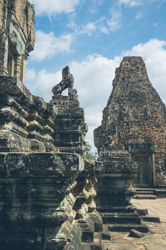 White clouds floating on blue sky over ruined buildings of old oriental temple on sunny day