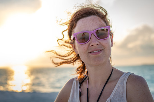 Beautiful female in trendy shades looking at camera on sunny day in Maldives