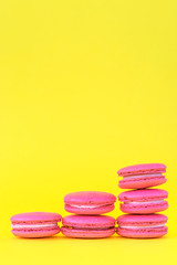 Pink macaroons on a yellow background. Concepts of classification and growth