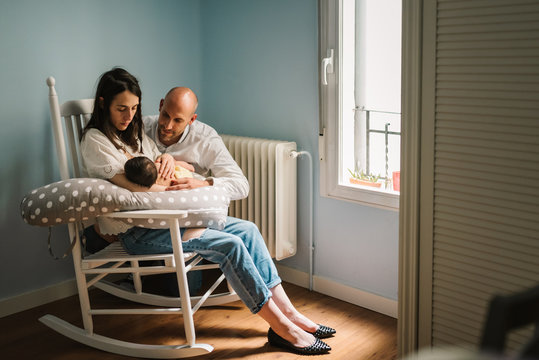 Parents feeding baby at home