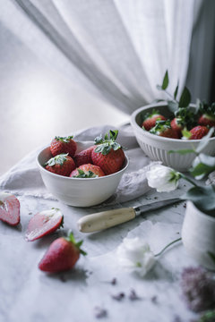 Strawberries and flowers on marble table