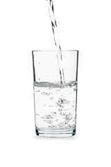 Pouring water into glass isolated on white