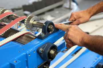 Detail of the hands of an attendant while assembling a machine