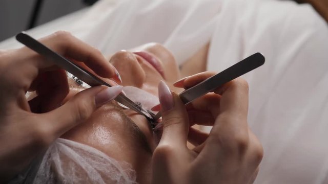 Beautiful Woman with long eyelashes in a beauty salon. Eyelash extension procedure. Lashes close up