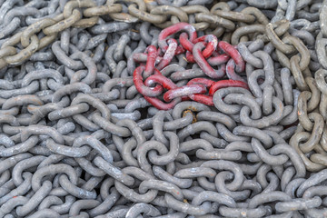 Grey and blood red steal chains at a shipyard