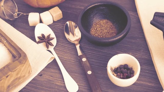 Spice, salt, sugar. Pink pepper, yellow spice, peppercorns and different condiments on wooden table.  Spicing and cooking concept. Slow pan. Selective focus. Foggy footage.