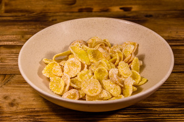 Ceramic plate with cornflakes on a wooden table. Healthy eating