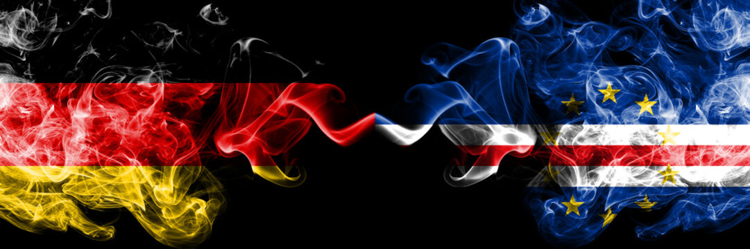 Germany vs Cape Verde smoky mystic flags placed side by side. Thick colored silky smoke flags of Deutschland and Cape Verde