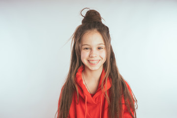 Fototapeta premium Children model on a white background. Little girl with long hair, wearing a red hoodie