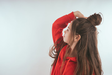 Children model on a white background.  Little girl with long hair, wearing a red hoodie