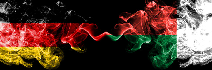 Germany vs Madagascar, Madagascan smoky mystic flags placed side by side. Thick colored silky smoke flags of Deutschland and Madagascar, Madagascan