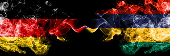 Germany vs Mauritius, Mauritian smoky mystic flags placed side by side. Thick colored silky smoke flags of Deutschland and Mauritius, Mauritian
