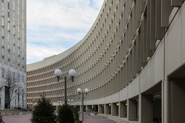 Curving government building with plaza in large urban area