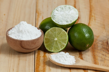 baking soda - sodium bicarbonate and lemon, on wooden background