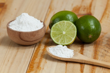 baking soda - sodium bicarbonate and lemon, on wooden background