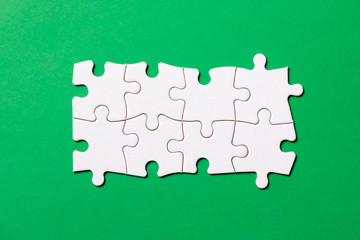 Eight pieces white jigsaw puzzle on green background for business presentation