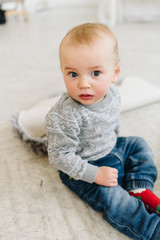 Fototapeta premium Cute little toddler boy sitting on the floor
