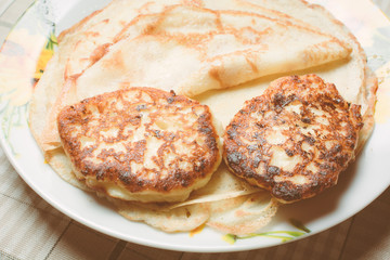 Fried curd cheese cakes on pancakes in plate.