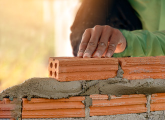 Close up of industrial bricklayer installing bricks