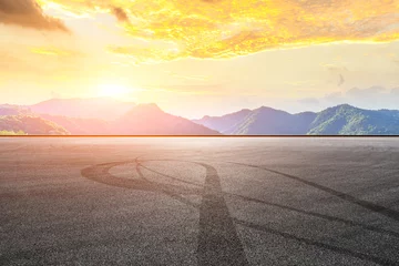 Fotobehang Formule 1 Empty asphalt race track and beautiful natural landscape at sunset  © ABCDstock