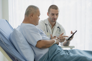 Obraz premium happy asian elderly looking at a good result of health check up in the medical chart with doctor.