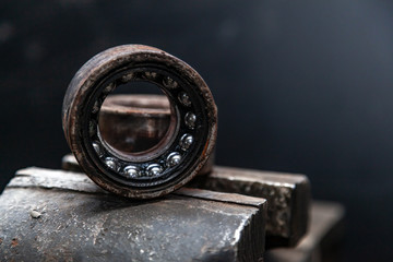 A close-up of a metal car spare part bearing from a supported car on a metal table in a car repair...