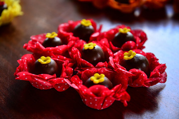 bunch of red flowers, brazilian sweet , chocolate candy, party candy, condensed milk candy balls, chocolate truffles, brigadeiro, chocolate sprinkles, chocolate candy, sweets table, chocolate truffles