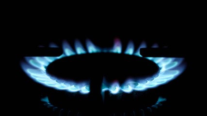 Flames of gas stove in the dark close up.