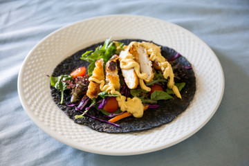 Black charcoal wrap with vegetables and chicken schnitzel