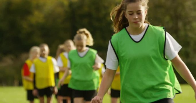 4K British girls' soccer team showing motivation & concentration at training session. Slow motion.