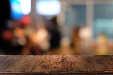 Empty dark wooden table in front of abstract blurred bokeh background of restaurant . can be used for display or montage your products.Mock up for space.