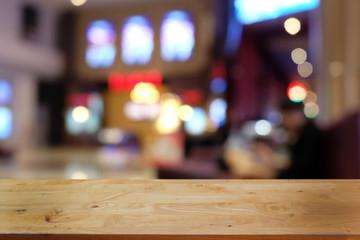 Empty dark wooden table in front of abstract blurred bokeh background of restaurant . can be used for display or montage your products.Mock up for space.