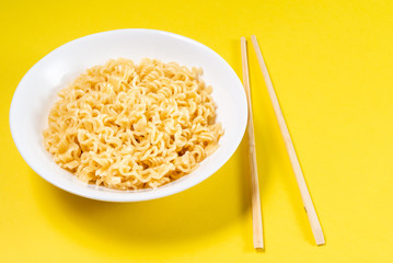 Soup Ramen noodles in ceramic bowl horizontal on a yellow background with copy space.