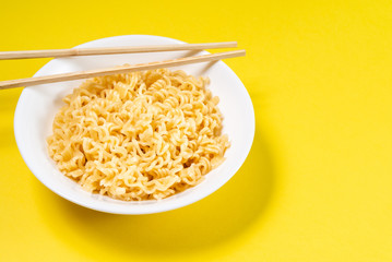 Soup Ramen noodles in ceramic bowl horizontal on a yellow background with copy space.