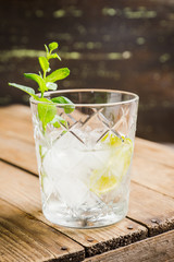 Old fashioned beverage with lime and mint leaves. Selective focus. Shallow depth of field.