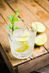 Old fashioned beverage with lime and mint leaves. Selective focus. Shallow depth of field.