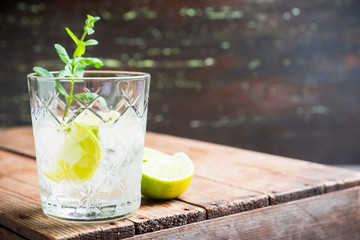 Old fashioned beverage with lime and mint leaves. Selective focus. Shallow depth of field.