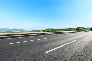 Fototapeta premium Country road and green mountains natural landscape under the blue sky