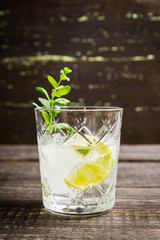 Old fashioned beverage with lime and mint leaves. Selective focus. Shallow depth of field.