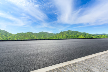 Country road and green mountains natural landscape under the blue sky