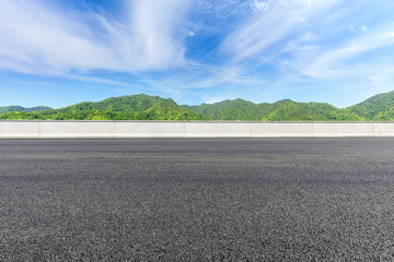 Country road and green mountains natural landscape under the blue sky
