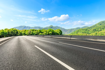 Country road and green mountains natural landscape under the blue sky