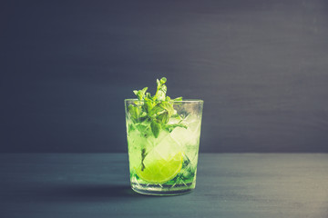 Summer old fashioned beverage with melon liqueur and mint leaves. Selective focus. Shallow depth of field.