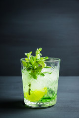 Summer old fashioned beverage with melon liqueur and mint leaves. Selective focus. Shallow depth of field.