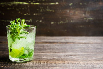 Summer old fashioned beverage with melon liqueur and mint leaves. Selective focus. Shallow depth of field.
