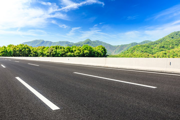 Country road and green mountains natural landscape under the blue sky
